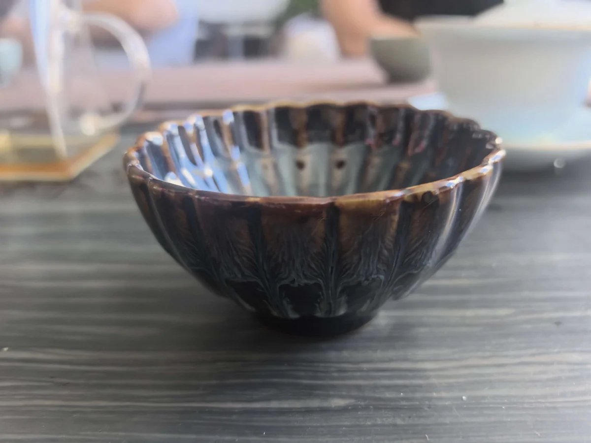 侧视实拍:茶碗的弧形轮廓、深色釉面与低矮圈足